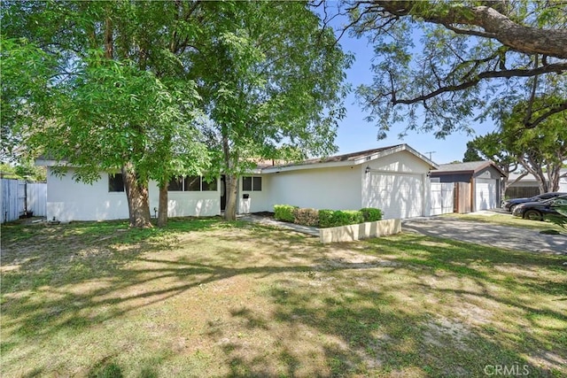 view of front facade featuring an attached garage, stucco siding, and a front lawn