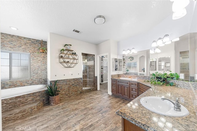7922 Los Palmas Dr, Oak Hills, CA 92344 - full bath featuring a bath, a sink, double vanity, wood finished floors, and a stall shower