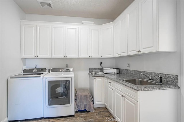 7922 Los Palmas Dr, Oak Hills, CA 92344 - clothes washing area with dark wood finished floors, independent washer and dryer, visible vents, a sink, and cabinet space
