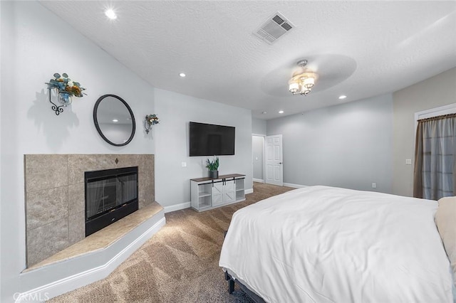 7922 Los Palmas Dr, Oak Hills, CA 92344 - bedroom with carpet, a textured ceiling, a glass covered fireplace, visible vents, and baseboards