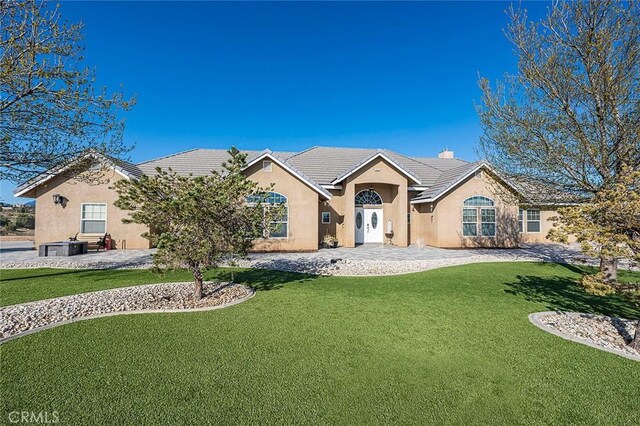 7922 Los Palmas Dr, Oak Hills, CA 92344 - ranch-style home featuring stucco siding, a front lawn, and a tile roof