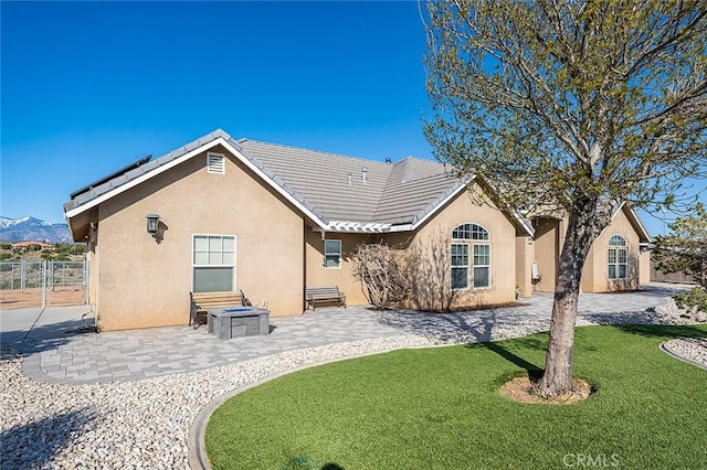 7922 Los Palmas Dr, Oak Hills, CA 92344 - rear view of property with a yard, stucco siding, a tiled roof, and fence