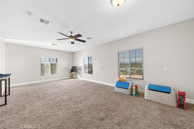 7922 Los Palmas Dr, Oak Hills, CA 92344 - game room with a wealth of natural light, visible vents, a ceiling fan, and carpet floors