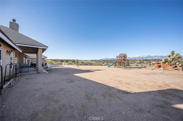 7922 Los Palmas Dr, Oak Hills, CA 92344 - view of yard with a mountain view and a playground