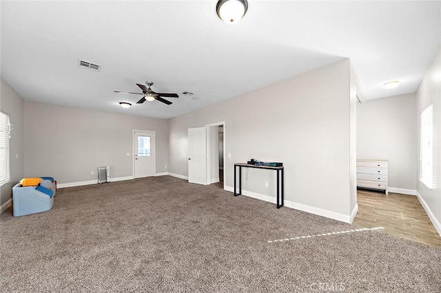 7922 Los Palmas Dr, Oak Hills, CA 92344 - interior space with visible vents, baseboards, ceiling fan, radiator heating unit, and carpet flooring