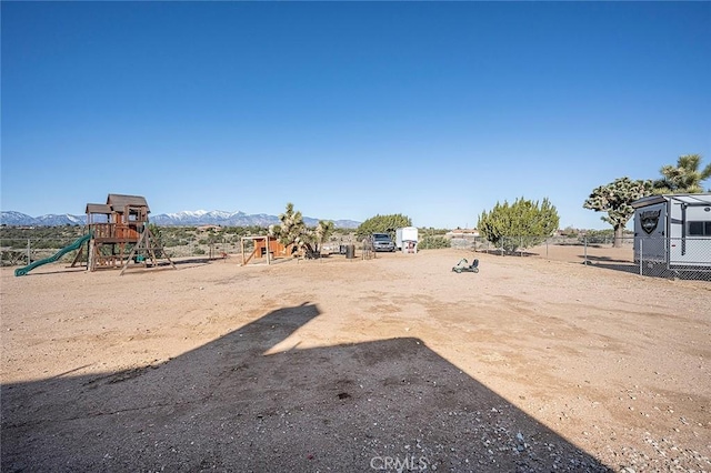 7922 Los Palmas Dr, Oak Hills, CA 92344 - view of yard with a mountain view, fence, and playground community