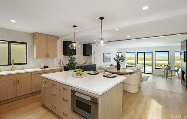 kitchen with light brown cabinetry, modern cabinets, and a sink