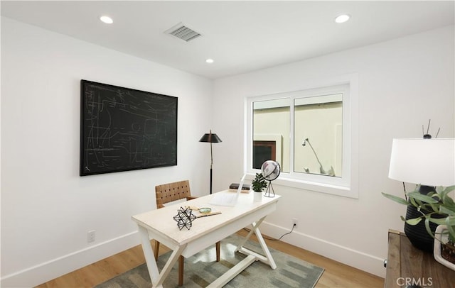 office area featuring baseboards, visible vents, and light wood-type flooring
