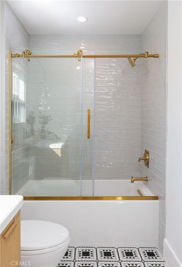 full bath featuring shower / bath combination with glass door, tile patterned floors, toilet, and vanity