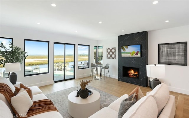 living room with a premium fireplace, recessed lighting, and baseboards