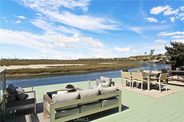 dock area with a deck with water view, an outdoor living space, and outdoor dining area