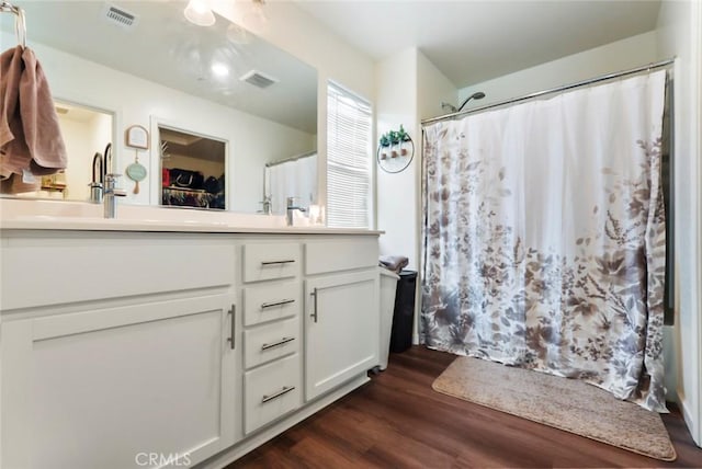 full bath featuring visible vents, a shower with curtain, vanity, and wood finished floors