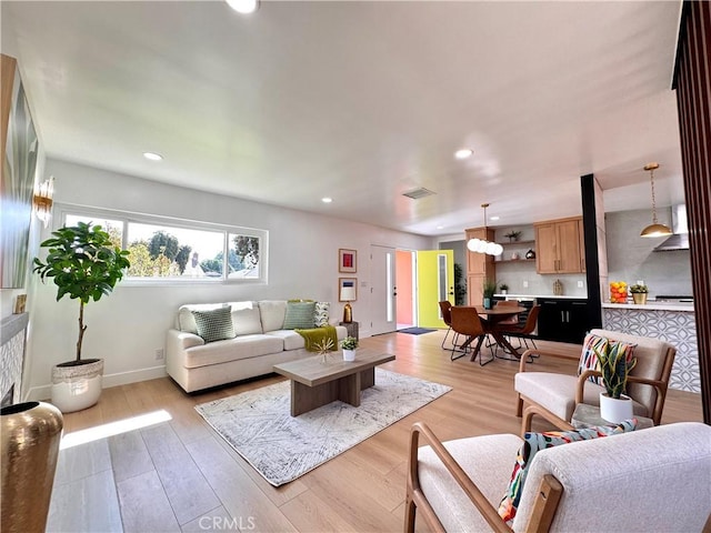 living area with visible vents, light wood-style flooring, recessed lighting, and baseboards