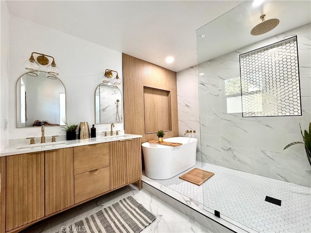 bathroom with a sink, a freestanding bath, marble finish floor, and double vanity