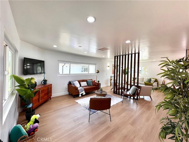 living room with recessed lighting, light wood-style flooring, baseboards, and visible vents