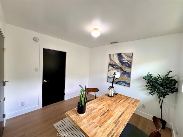 office space with visible vents, baseboards, and wood finished floors