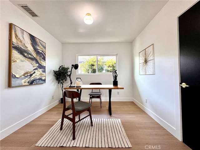 home office with visible vents, light wood-style flooring, and baseboards