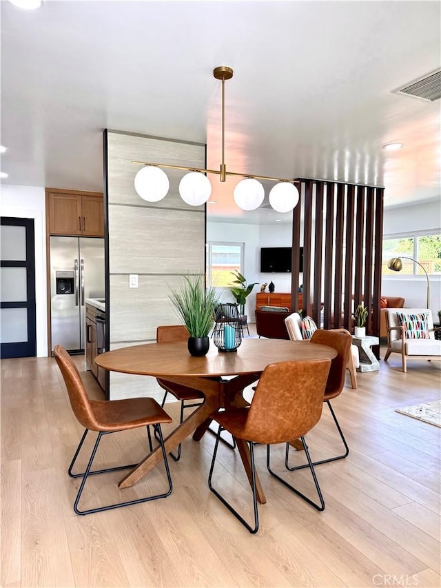 dining area with visible vents and light wood-style flooring