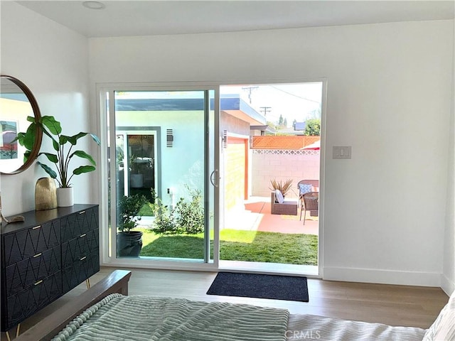 doorway featuring baseboards and wood finished floors