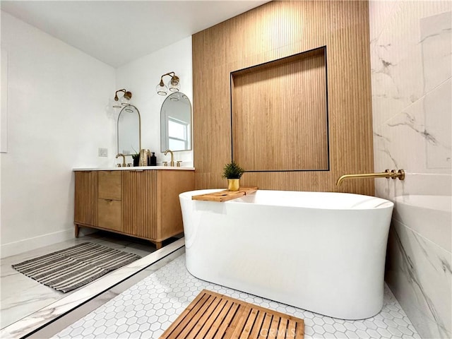bathroom with a freestanding bath, tile patterned floors, baseboards, and double vanity