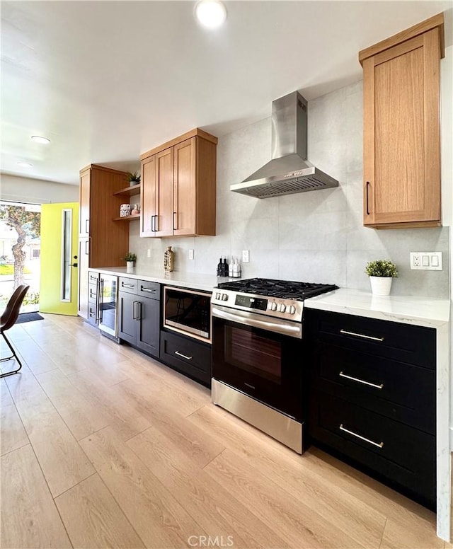 kitchen with tasteful backsplash, open shelves, built in microwave, wall chimney exhaust hood, and stainless steel range with gas cooktop