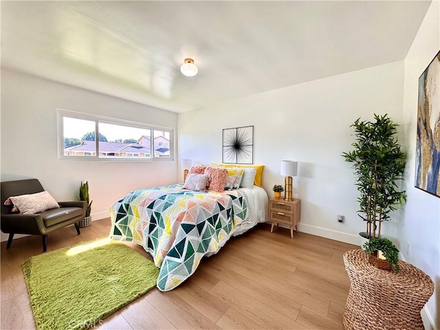 bedroom with light wood-style flooring and baseboards