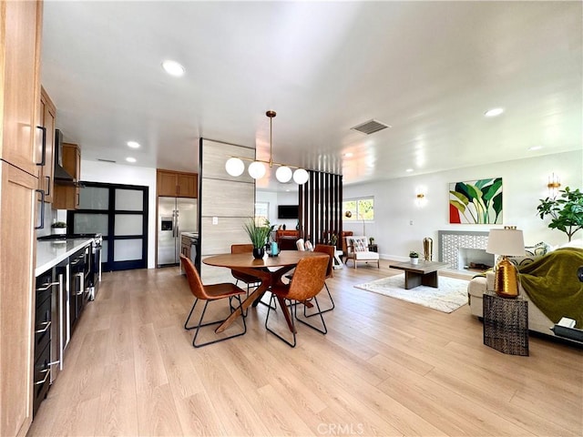 dining space featuring light wood finished floors, baseboards, visible vents, and recessed lighting