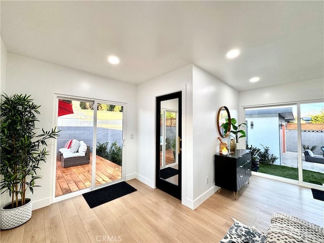 doorway with light wood-style floors, baseboards, and recessed lighting