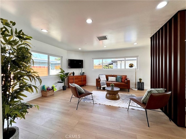 living room featuring light wood-style floors, baseboards, visible vents, and recessed lighting
