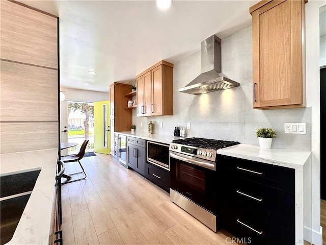 kitchen featuring open shelves, wall chimney exhaust hood, stainless steel gas range, light wood-style flooring, and built in microwave
