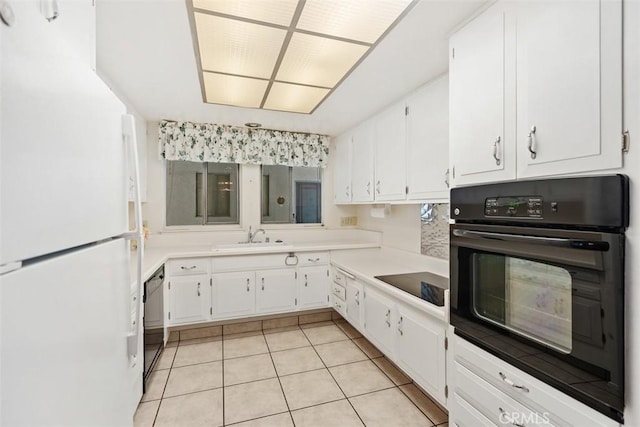 kitchen featuring light tile patterned floors, white cabinets, black appliances, a sink, and light countertops