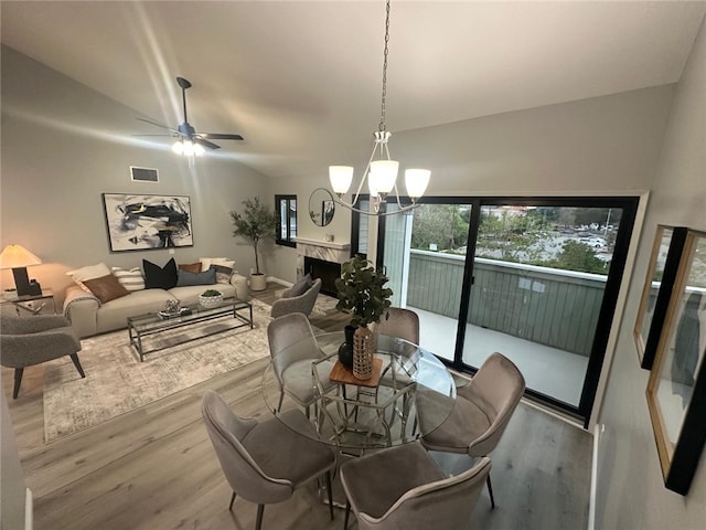 27130 Hidaway Ave Unit 6, Canyon Country, CA 91351 - dining room featuring wood finished floors, a chandelier, a ceiling fan, and a high end fireplace