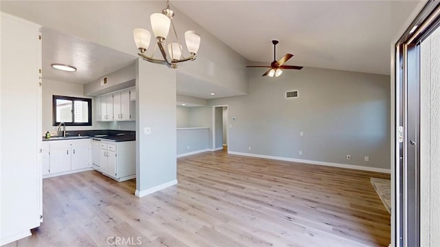 27130 Hidaway Ave Unit 6, Canyon Country, CA 91351 - kitchen featuring dark countertops, light wood-style flooring, a ceiling fan, white cabinetry, and vaulted ceiling