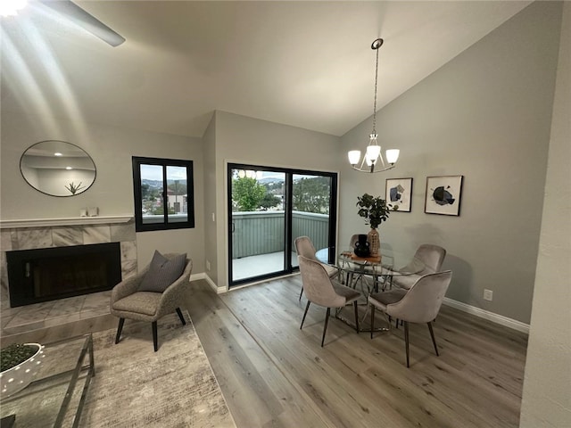27130 Hidaway Ave Unit 6, Canyon Country, CA 91351 - dining space with wood finished floors, baseboards, a tiled fireplace, a chandelier, and high vaulted ceiling