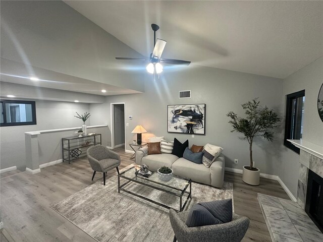27130 Hidaway Ave Unit 6, Canyon Country, CA 91351 - living room featuring wood finished floors, lofted ceiling, baseboards, a tiled fireplace, and a ceiling fan