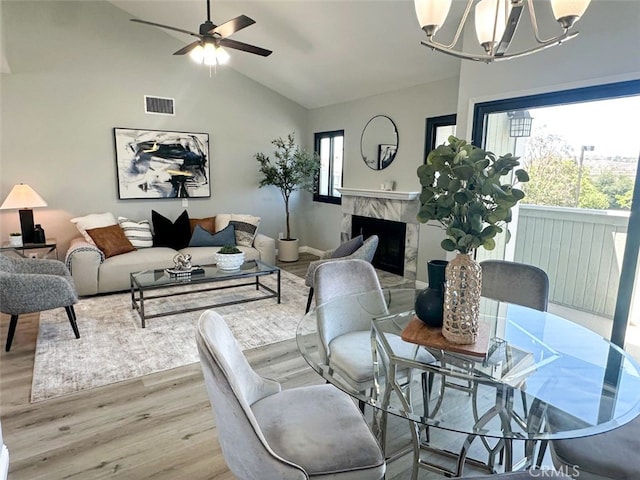 27130 Hidaway Ave Unit 6, Canyon Country, CA 91351 - living area featuring light wood-type flooring, a chandelier, vaulted ceiling, a ceiling fan, and a fireplace