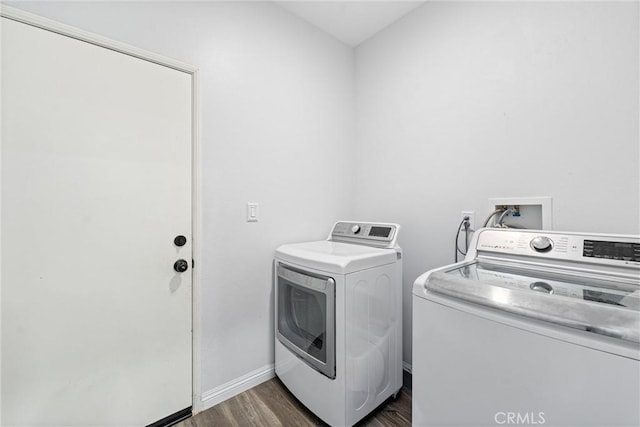 laundry area with dark wood-type flooring, laundry area, washing machine and clothes dryer, and baseboards