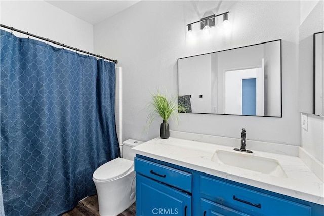 bathroom with toilet, vanity, and a shower with curtain
