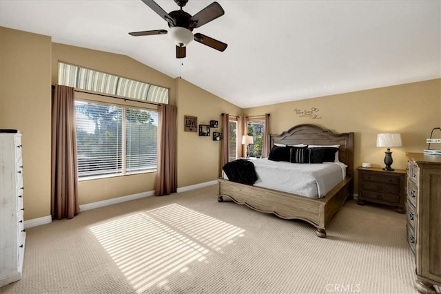 bedroom featuring lofted ceiling, multiple windows, baseboards, and light colored carpet