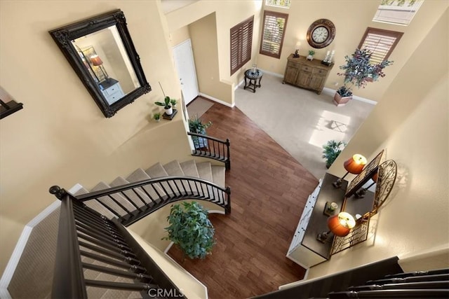 stairway with wood finished floors and baseboards