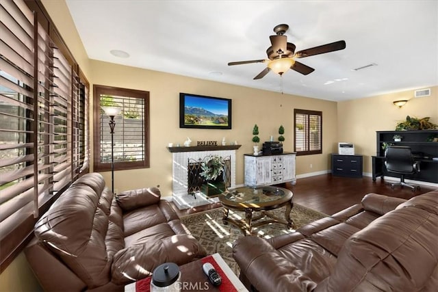 living room featuring baseboards, ceiling fan, visible vents, and wood finished floors