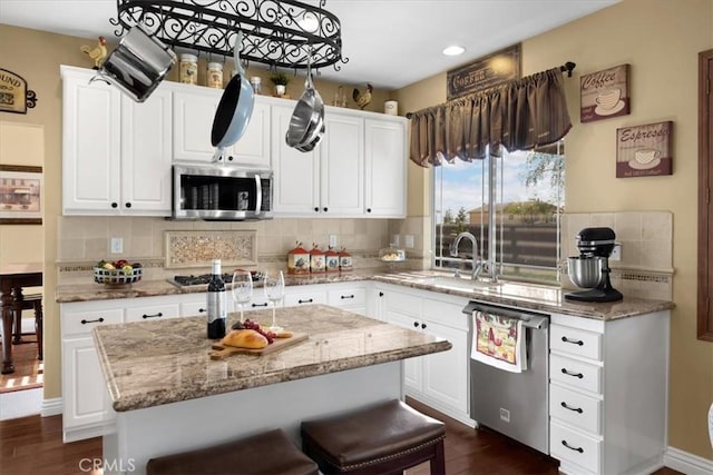 kitchen featuring appliances with stainless steel finishes, dark wood-style flooring, tasteful backsplash, and a sink