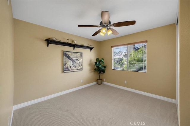 empty room featuring carpet, baseboards, and a ceiling fan