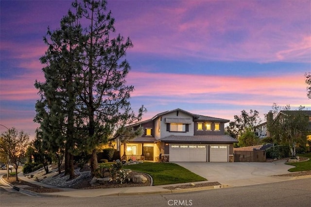 traditional home featuring a yard, concrete driveway, an attached garage, and stone siding