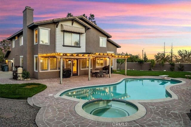 back of house with a chimney, a patio, a pool with connected hot tub, stucco siding, and a pergola