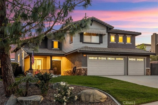 view of front facade featuring driveway, a garage, stucco siding, a porch, and a front lawn