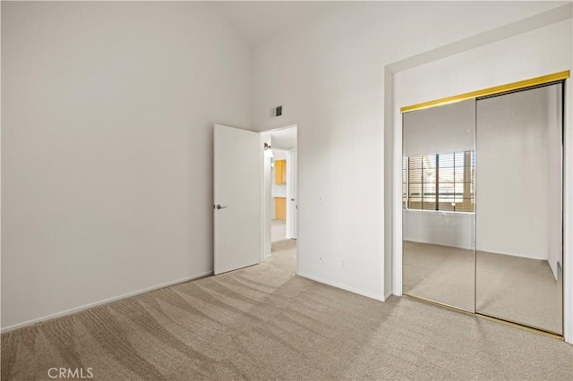 18217 Flynn Dr Unit 116, Canyon Country, CA 91387 - unfurnished bedroom featuring a closet, baseboards, visible vents, a towering ceiling, and carpet floors
