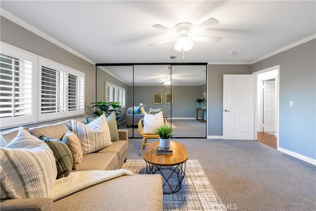 living area featuring ornamental molding, baseboards, a ceiling fan, and carpet flooring