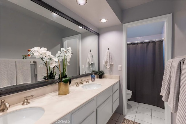 bathroom with toilet, double vanity, a sink, and recessed lighting