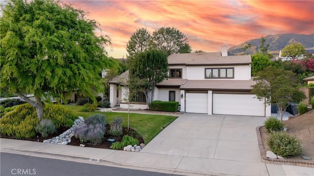 view of front facade with stucco siding, a chimney, driveway, a garage, and a tiled roof